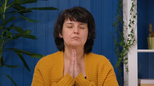 Middle Aged Woman Pray with Hope Faith Holding Hands Together Alone at Home alt