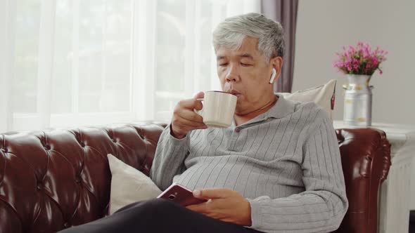 Senior man use wireless earphone listening music and talking telephone
