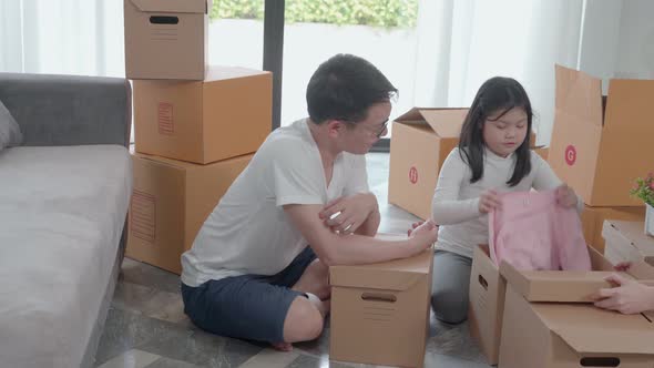 happy Asian family moving to new house with cardboard boxes and arrange the house.