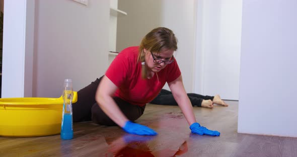 Plump Woman Washes Blood Stain From Parquet Near Corpse