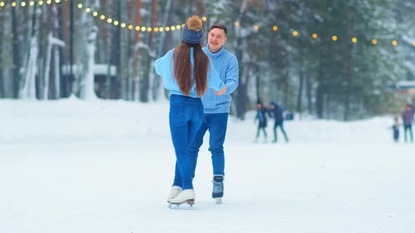 Man and Girl in Jeans and Sweaters Skate Joining Hands
