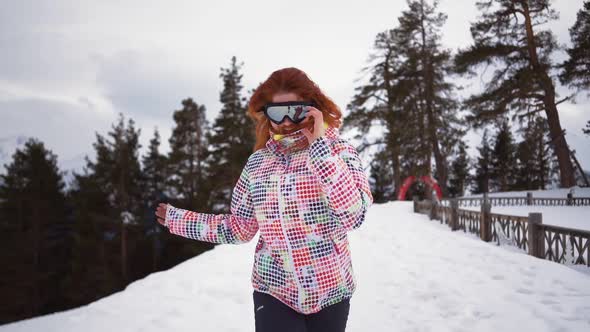 Happy Girl in Skiing Equipment Runs and Smiles of Snowy Mountains and Forest alt