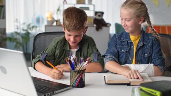 Distance Education Cute Boy Elementary School Pupil Learns Lessons Online with His Sister with alt