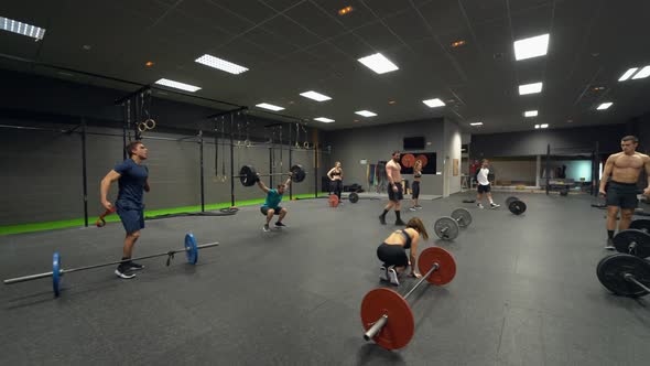 Disabled athlete training weight lifting with group at gym