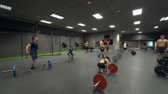 Disabled athlete training weight lifting with group at gym alt