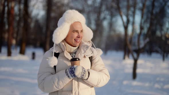 Portrait of a Homosexual Man Walking in a Winter City Park in Warm Clothes with a Disposable Cup of alt