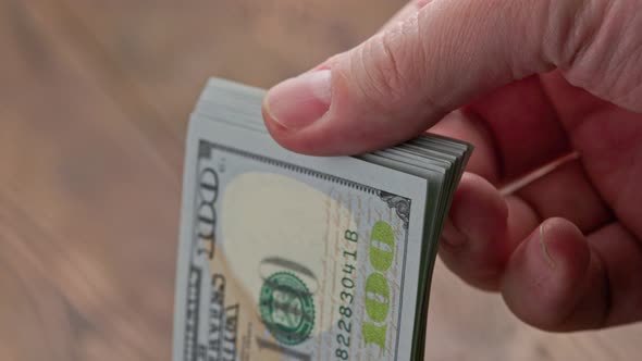 Caucasian Hand Checking Small Stack of Hundred Us Dollar Banknotes
