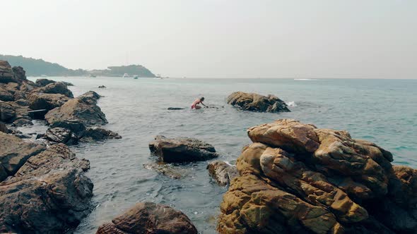 Girl Stands on Stone and Straightens Dark Brown Hair alt
