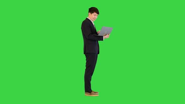 Asian Man Working with Laptop on a Green Screen Chroma Key