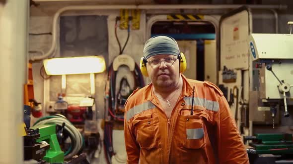 Marine Engineer Inspecting Ship's Engine in Engine Control Room alt