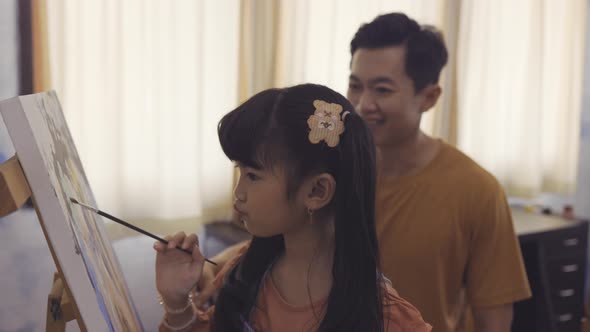 Family of Young Father Teaching His Daughter About Drawing Together alt