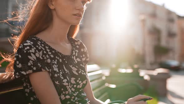 Thoughtful Young Redhead Girl in Black and White Dress with Pen and Notebook Looking Down in alt