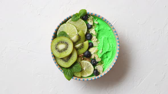Green Smoothie or Yogurt Bowl. With Fresh Kiwi, Blueberries, Lime and Almond Flakes alt