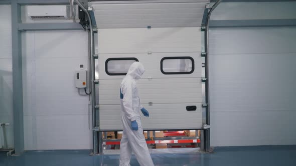 a Worker in a Special Uniform Opens a Warehouse
