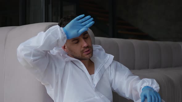 The tired man squatted down, took off his goggles, respirator, and protective suit hood. alt