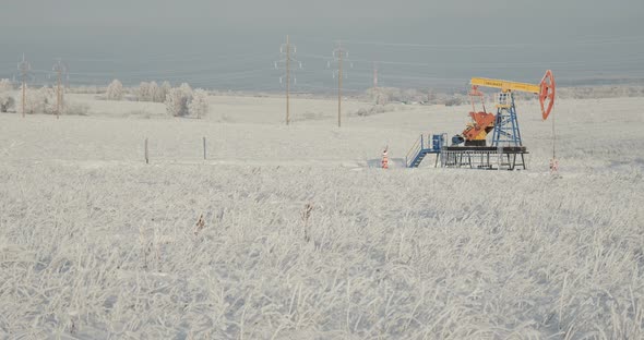 Oil Rig Stands in a Snowy Field alt