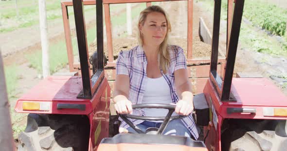 Video of happy caucasian woman driving tractor alt