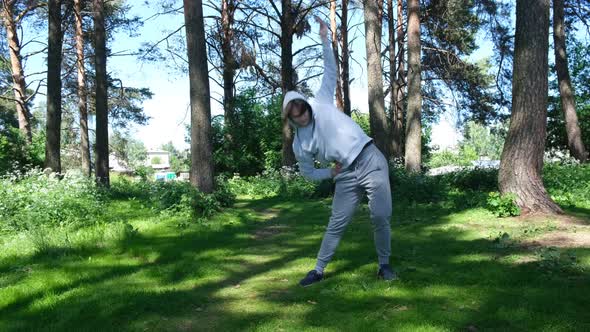 Single Young Man Doing Exercises in the Forest Park Street Workout