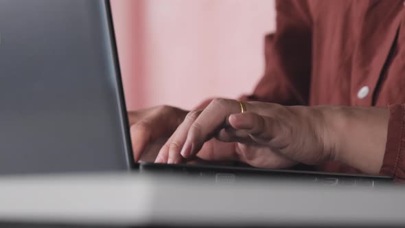 Beautiful Asian woman in casual clothes uses a laptop while working indoors. alt