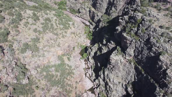 Drone footage from Arizona mountains near Payson with canyons and a creek with a waterfall. alt
