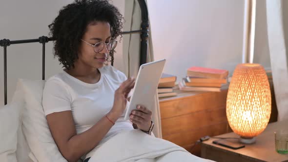 Attractive African Woman Using Tablet in Bed alt