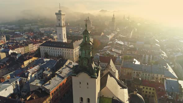 Flying Over Morning Foggy Lviv City in Ukraine. Scenic Summer Aerial View of the Market Square alt
