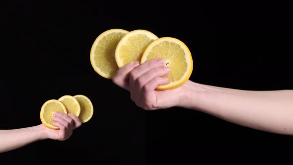 A Woman's Hand Holds Slices of Ripe Orange in Her Hand