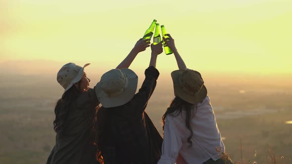Happy Asian young women having fun holding bottles of beer and celebrating