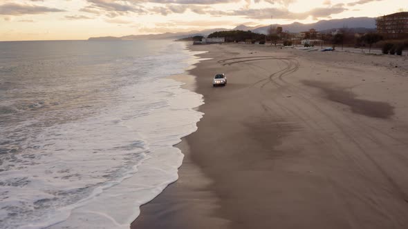 Vehicle off road splash into the wave on the beach alt