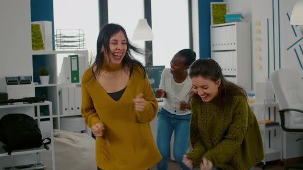 Mixed Raced Happy Women Dancing Cheerfully in Startup Creative Agency Office alt