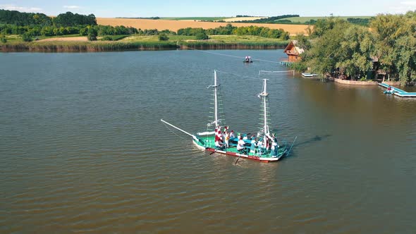 Old boat floating near the island with house in the river alt