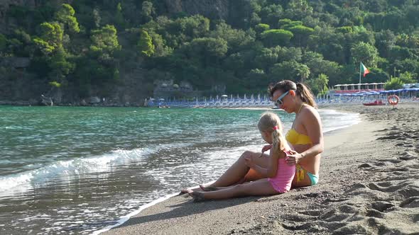 Mother and Daughter Resting at Italian Beach alt