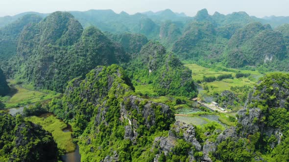 Aerial: North Vietnam karst landscape at sunset, drone view of Ninh Binh region, tourist destination alt