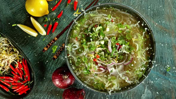 Super Slow Motion Shot of Ingredients Falling Into Vegetable Pho Soup at 1000 Fps. alt