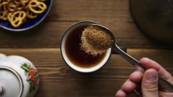 Pour Cane Sugar From Spoon Into Cup of Tea alt