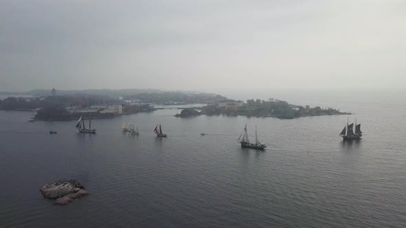 Aerial footage of tradtional wooden sailing ships sailing in front of port of Helsinki Finland alt