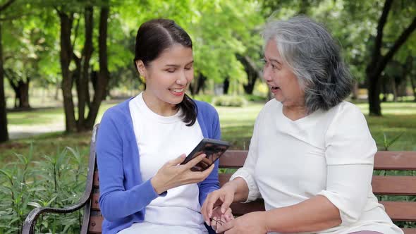 Elderly Mother And Asian Daughter Lounging In The Park Stock Footage