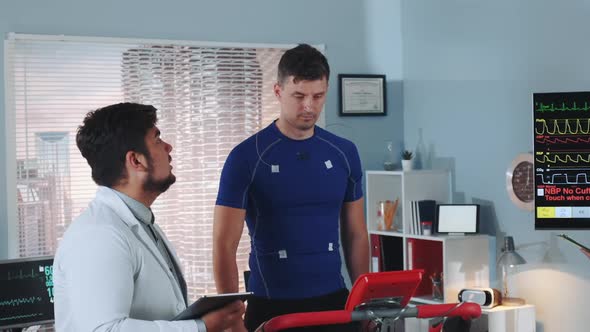 Multiracial Doctor Telling Athlete About Something During Stress Testing alt