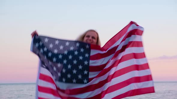Happy Smiling Woman in Summer Clothes with National USA Flag Outdoors Ocean Sunset American Flag alt