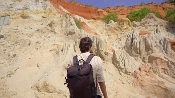 A Man Tourist Visits the Red Canyon or Fairy Stream at the Border of Desert in the Mui Ne Village in alt