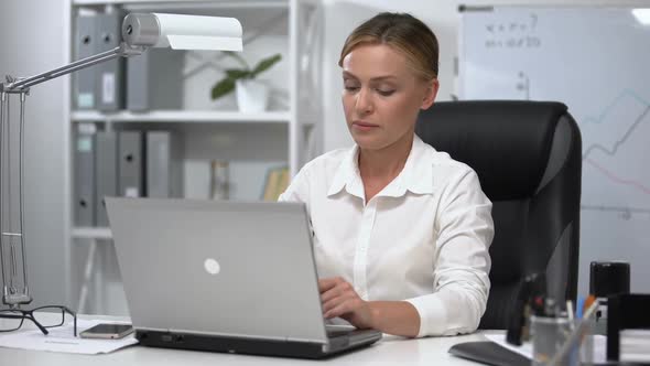 Business Lady Feeling Pain in Lower Back Trying to Stand Up After Working Day