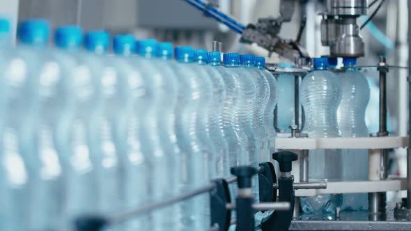 Water Bottles Moving on Automatic Conveyor Line in Water Production Factory