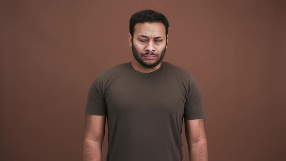 Grumpy Indian Man Looking Around and Folding His Arms Feeling Sad and Offended Brown Studio alt
