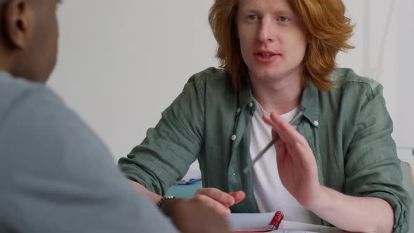 Young Redhead Millennial Talking to Colleagues alt