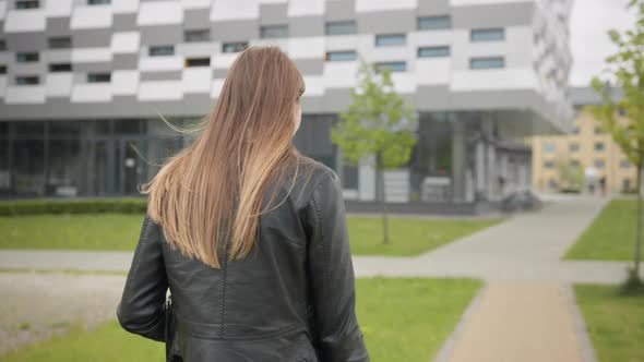 A Portrait of a Young Girl a Student Near a College or Modern Office Walking alt