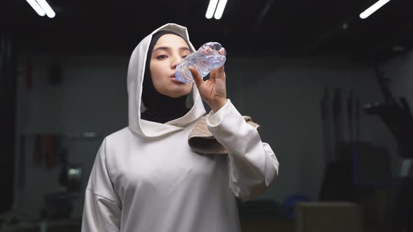 Muslim Woman is Resting After a Hard Workout She Drinks Fresh Water to Replenish the Water Balance