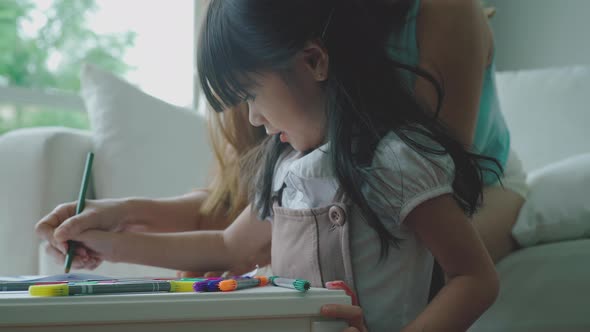 An Asian Mother Teaching Her Daughter at Home 18 alt