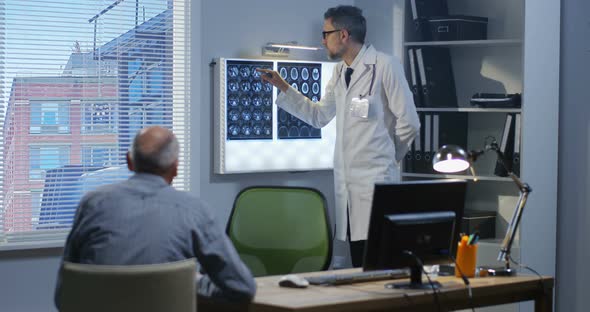 Male Doctor Explaining Brain Scan To Patient alt