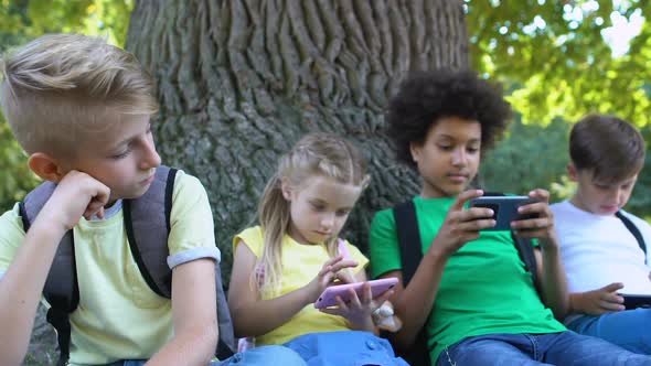 Sad Child Looking at Friends Scrolling Smartphones Feeling Bored, Communication