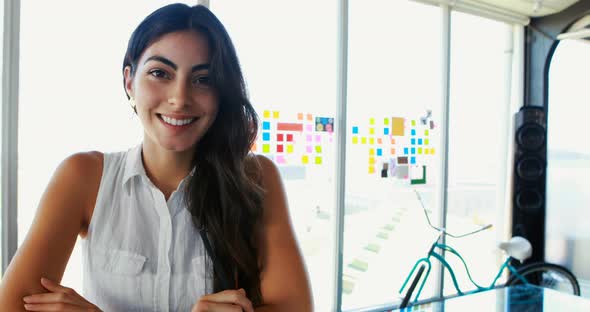 Female executive smiling at desk in office alt